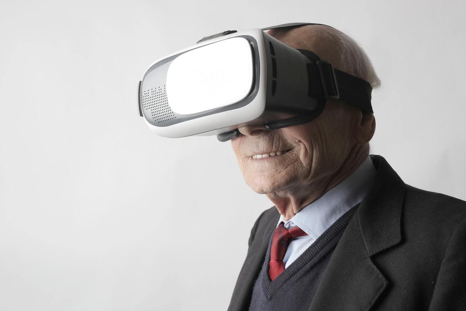 un hombre mayor sonriendo mientras se encuentra usando gafas de Realidad Virtual