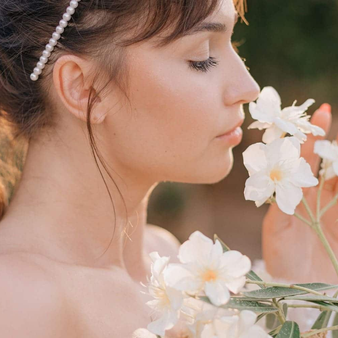 una mujer oliendo unas flores