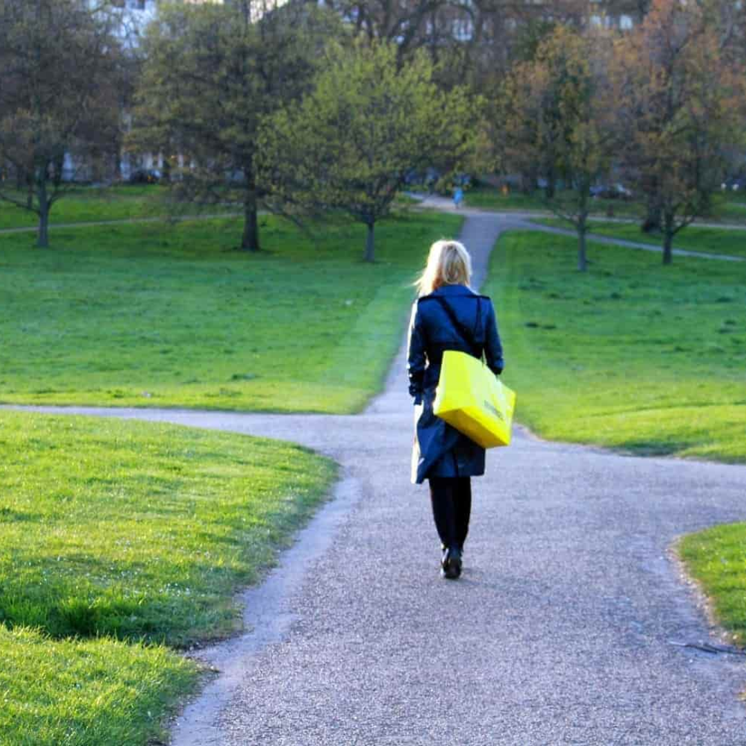 una mujer caminando por una calle rodeada de naturaleza