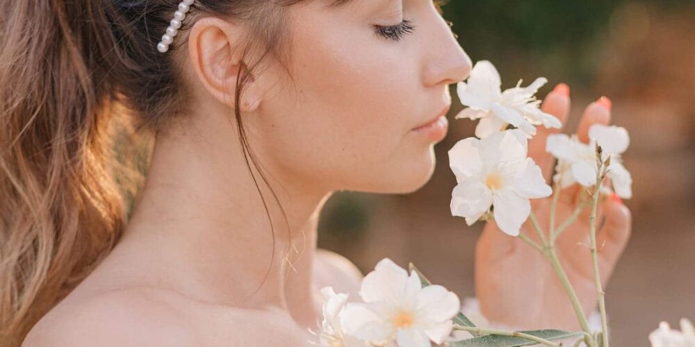una mujer oliendo unas flores