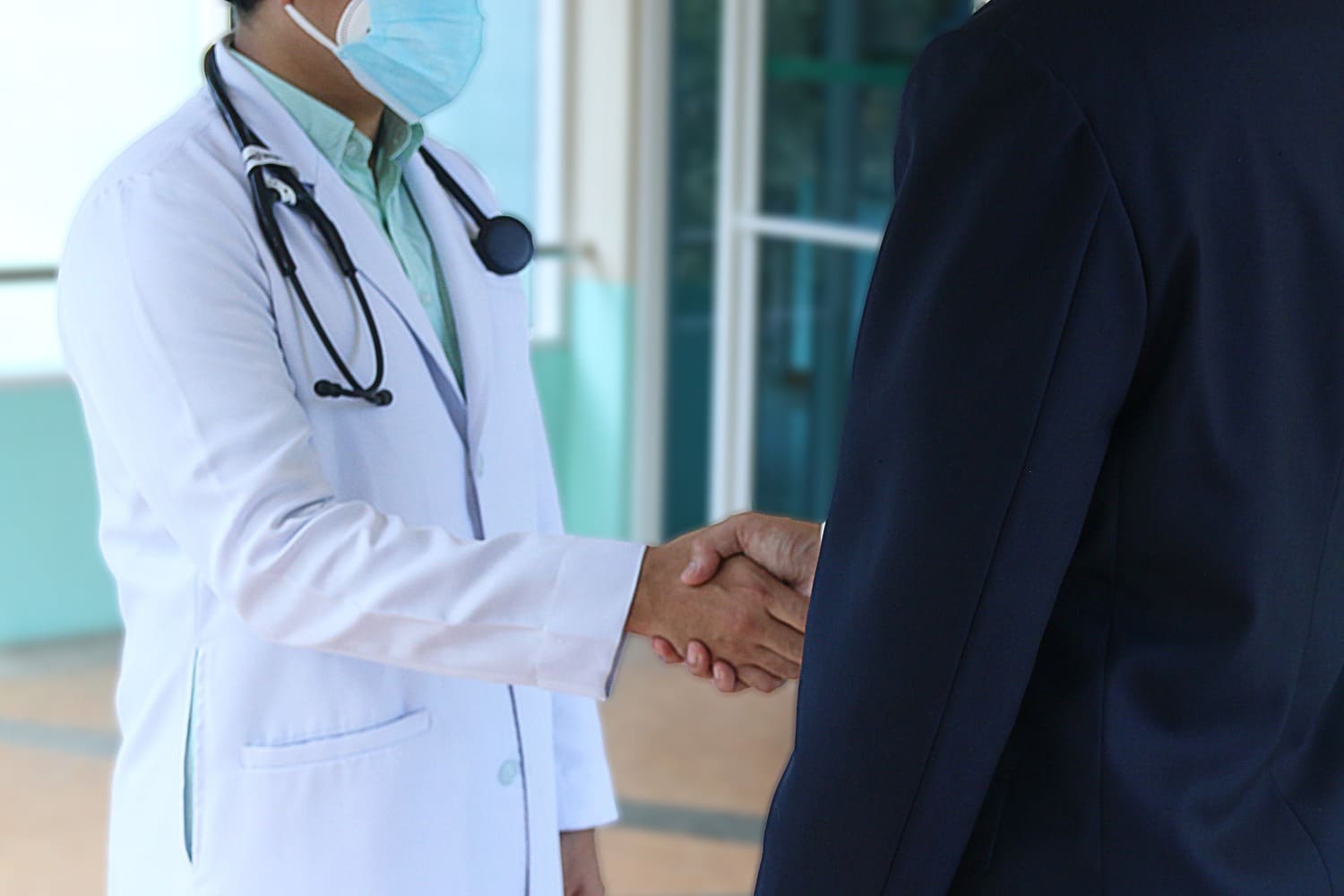 un hombre le da la mano a un médico