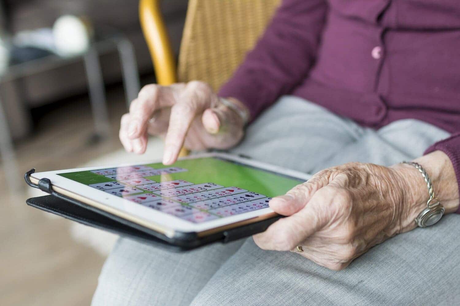 una persona mayor usando un dispositivo electrónico (una tablet)