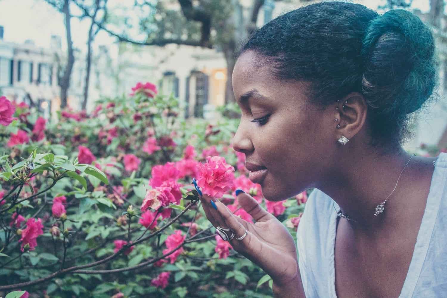 una mujer en un jardín oliendo unas flores