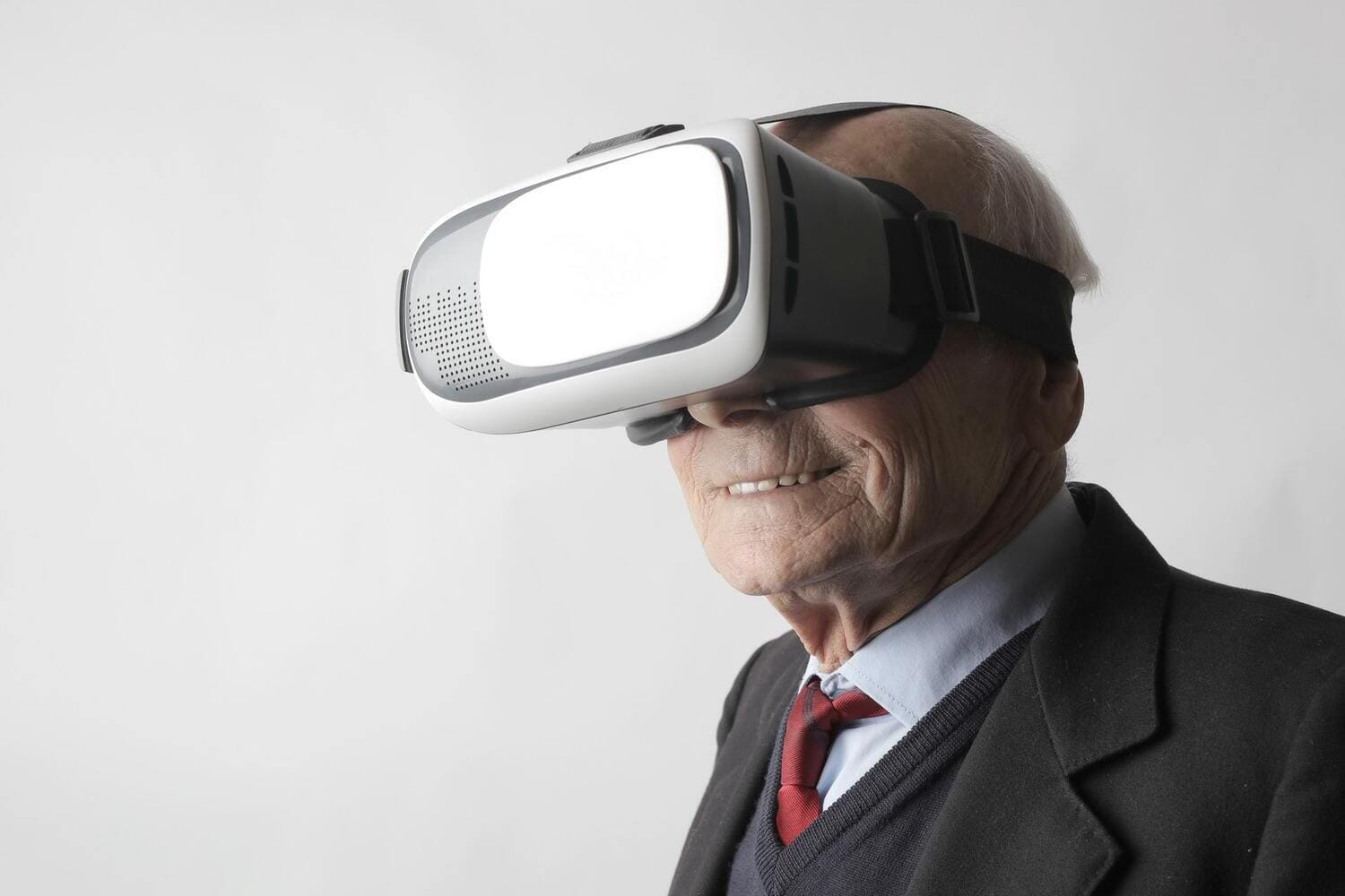 un hombre mayor sonriendo mientras usa gafas de Realidad Virtual