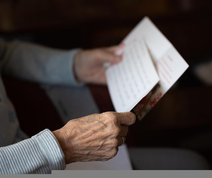 las manos de un adulto mayor que sostiene unos documentos