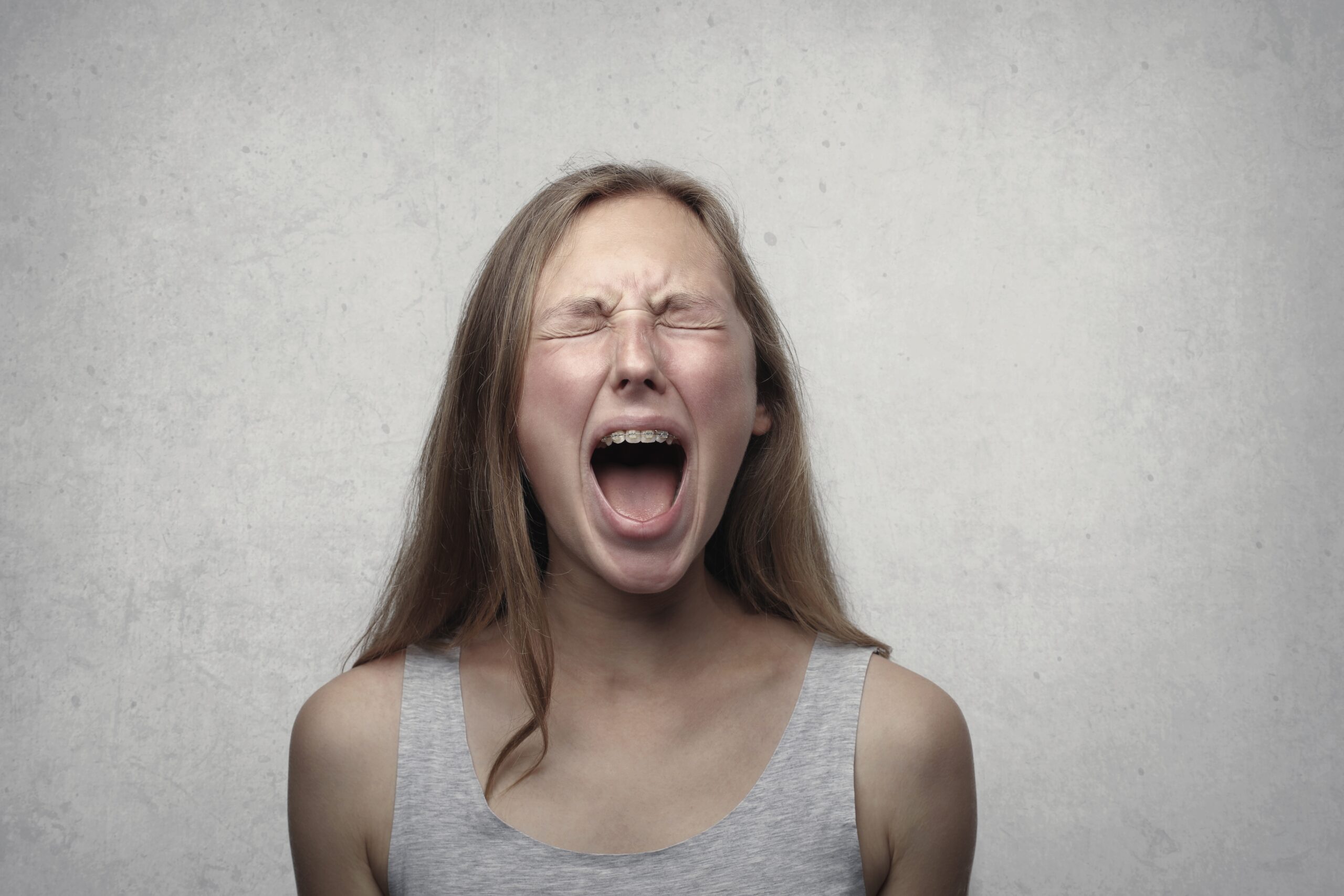 una mujer gritando con los ojos cerrados