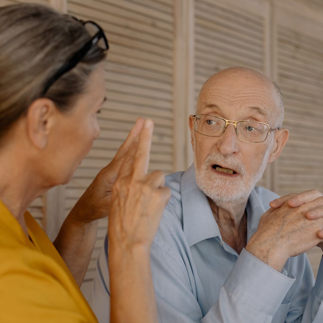 un adulto mayor, comunicándose con otra persona. la imagen hace referencia a la importancia de la capacidad lingüística y como sirve el lenguaje como predictor de demencia