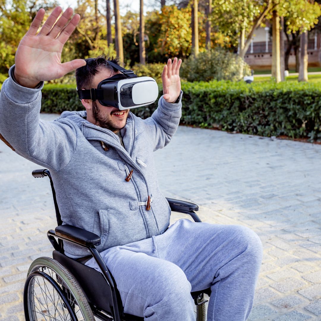 en la imagen se observa a un hombre en silla de ruedas que parece estar disfrutando de lo que ve gracias a las gafas de rv que está usando