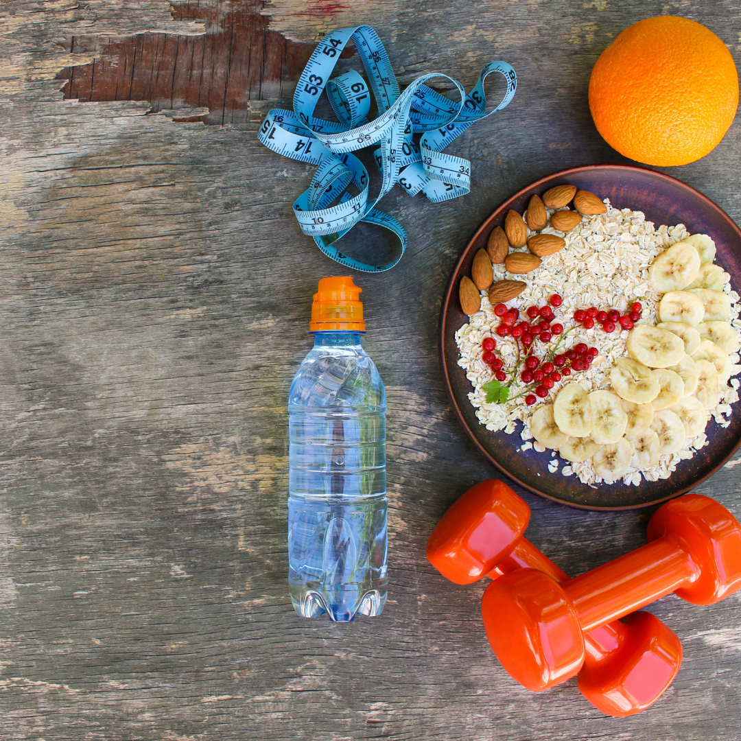 en la imagen hay un metro, una botella de agua, unas pesas, una fruta, un bol con frutos secos, avena y frutas. Todo esto hace referencia a hábitos de vida saludable