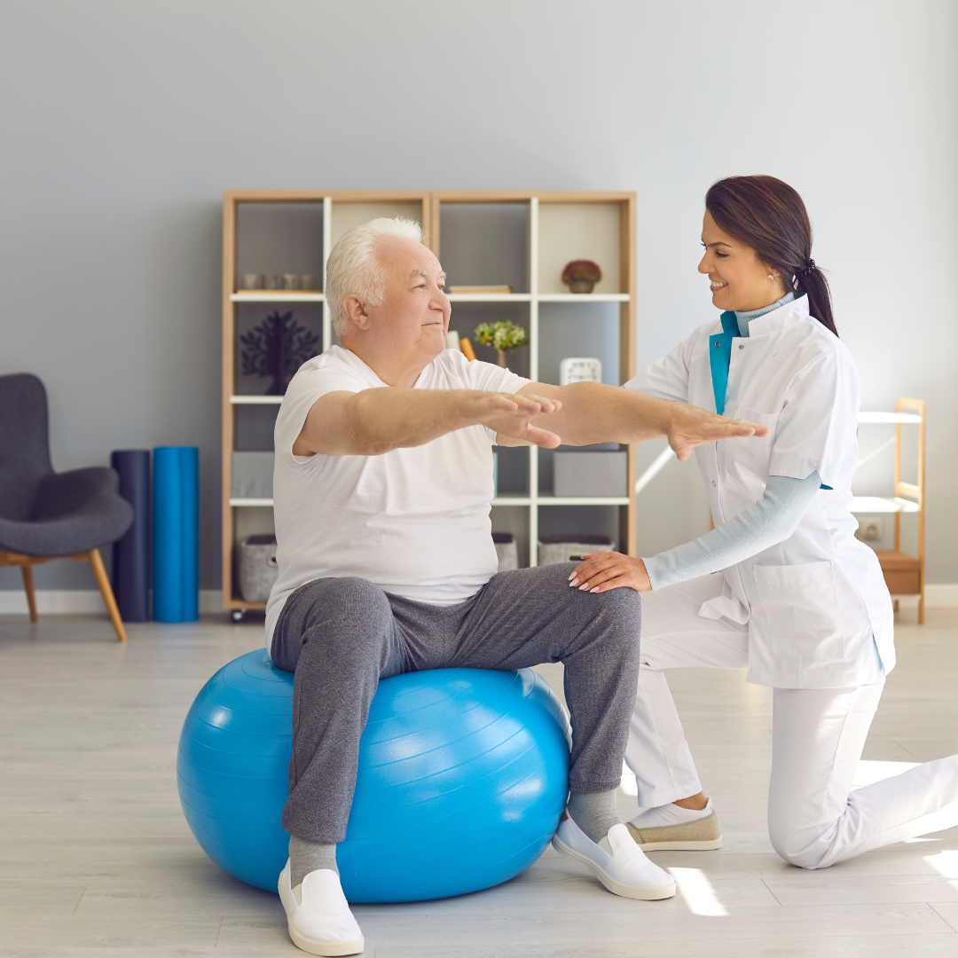 sesión de fisioterapia de una persona mayor: un adulto mayor esta haciendo ejercicio sobre una pelota, acompañado de una fisioterapeuta