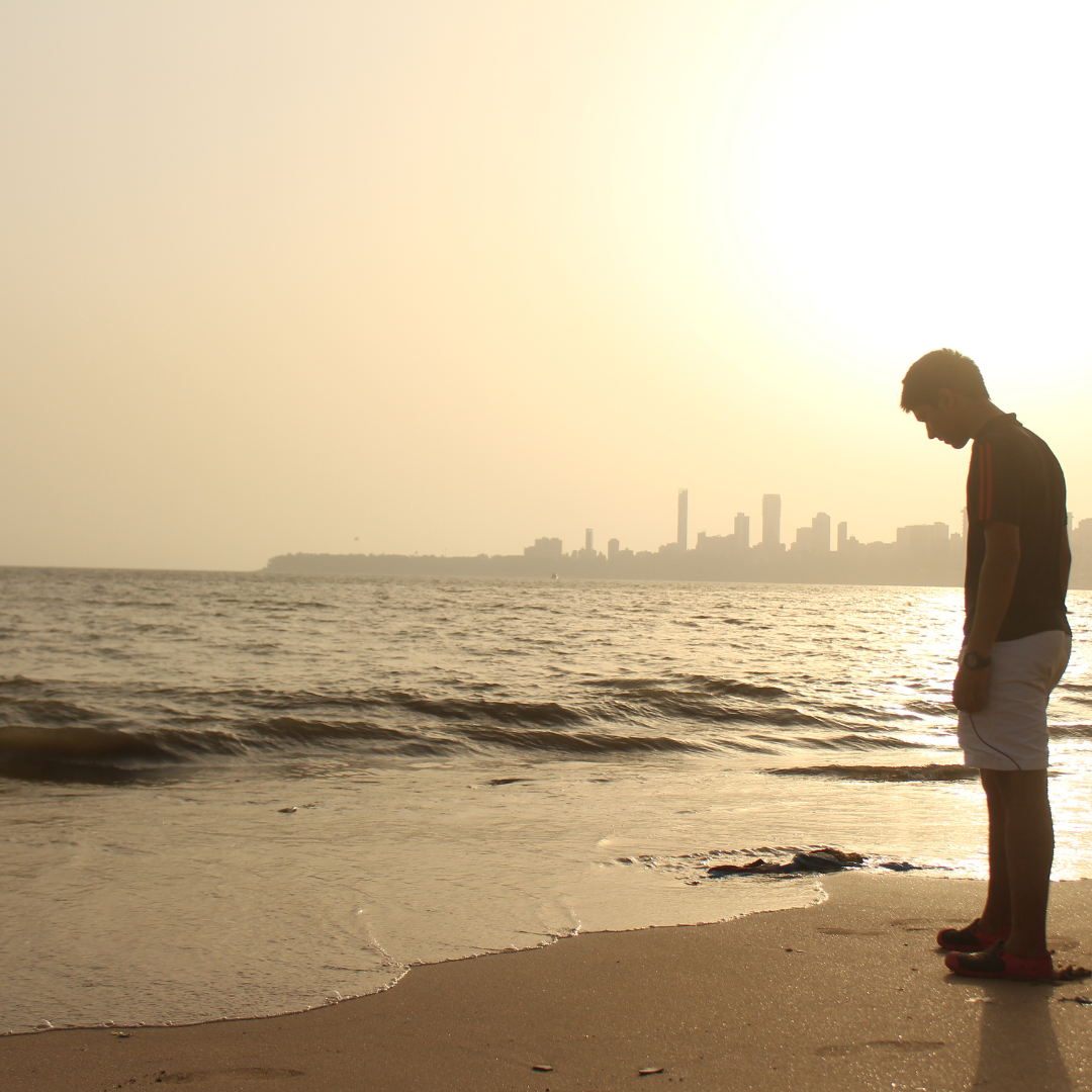 un hombre a la orilla de la playa, mirando el mar; imagen que hace referencia a uno de los síntomas de la depresión