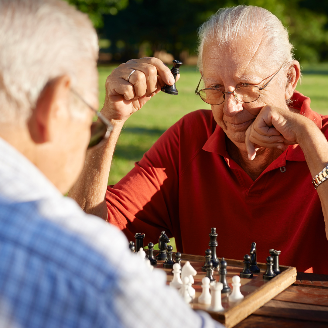 2 adultos mayores, jugando al ajedrez, aludiendo a ejercicios que ayudan a mantener la mente activa