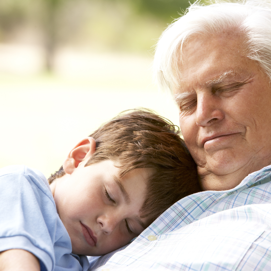 un abuelo junto con su nieto, durmiendo o tomando una siesta. Imagen que hace referencia a la importancia del sueño en las personas mayores