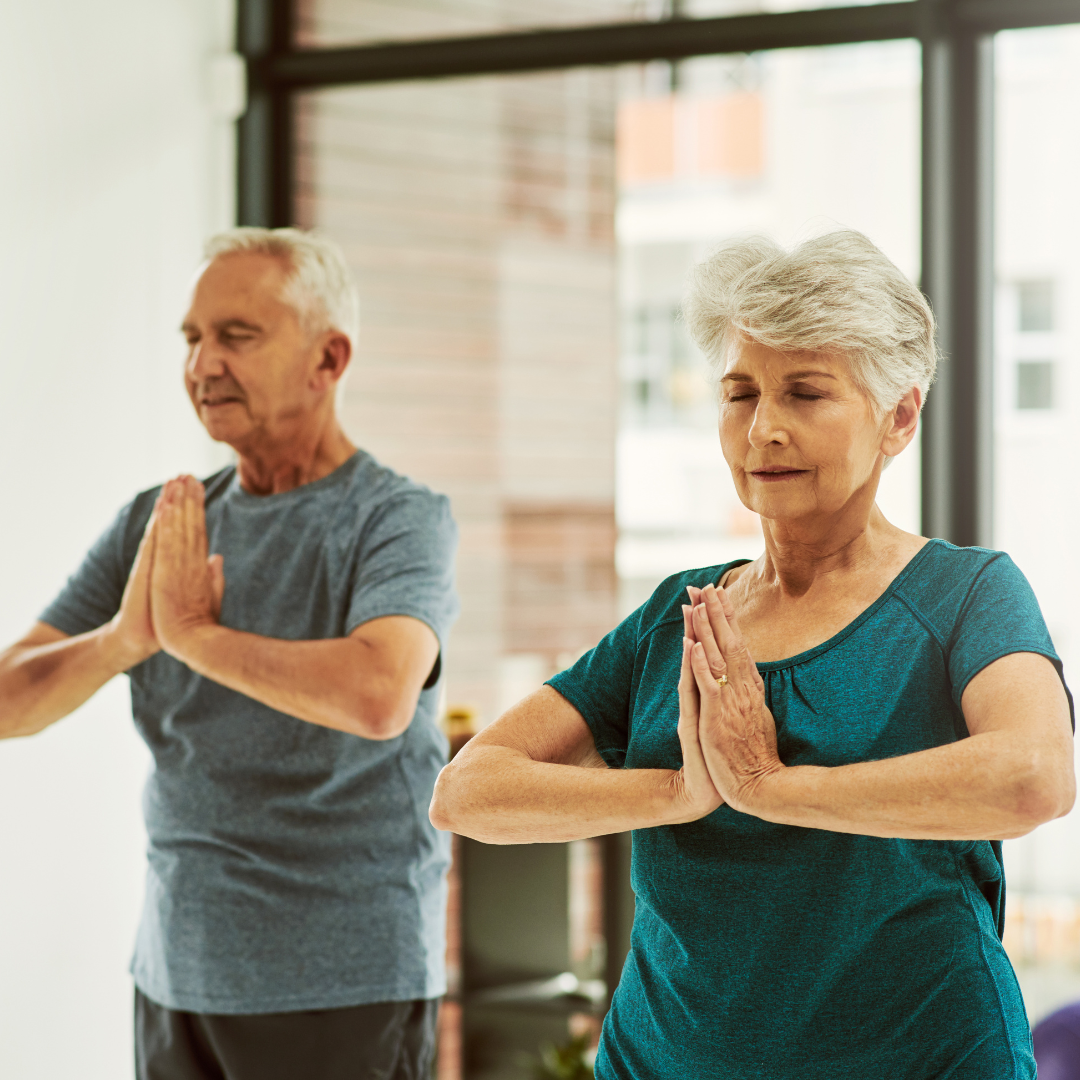 dos personas mayores practicando técnicas de relajación, posiblemente se trata de mindfulness. Imagen que sirve de ejemplo de como explorar la conexión mente-cuerpo