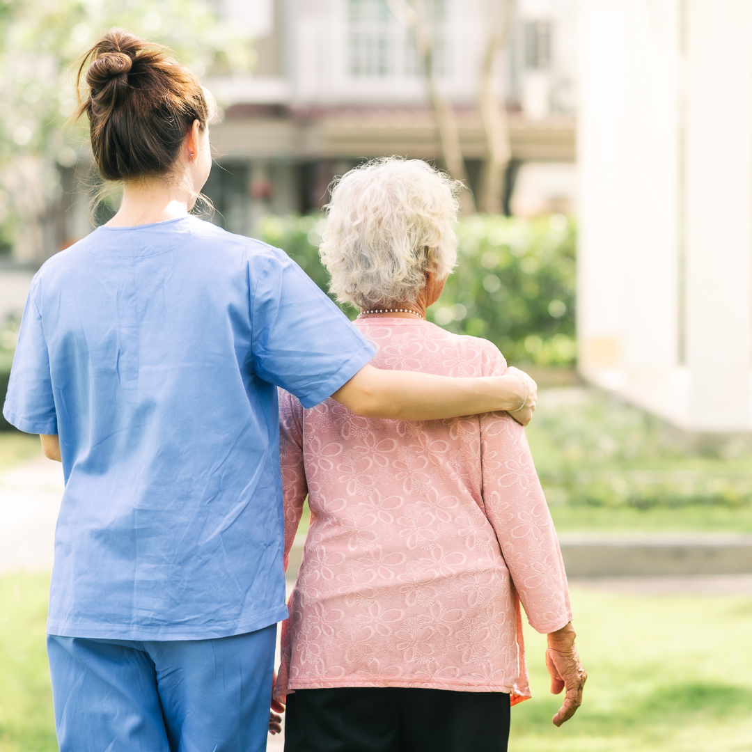 foto de una cuidadora y la persona que cuida, caminando abrazadas. imagen que busca hacer alusión a los cuidadores de pacientes con parkinson