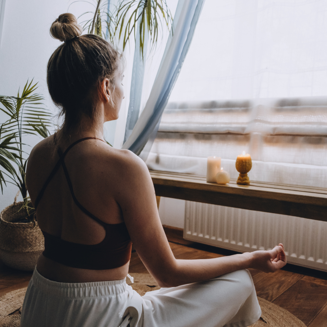 una mujer practicando la meditación como técnica de cuidado de la salud mental en casa