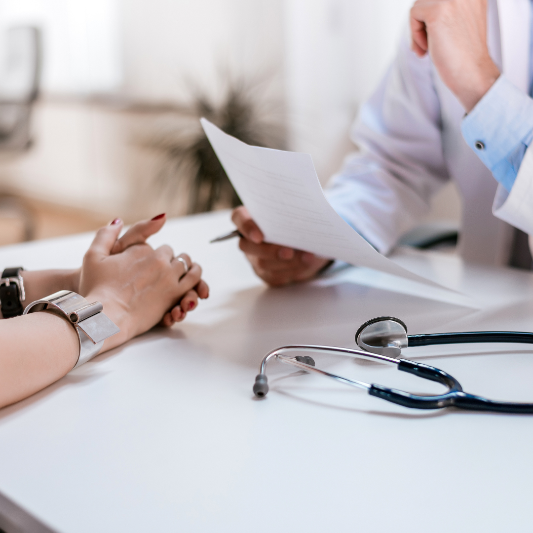 las manos y brazos de lo que parece ser una paciente frente a un doctor. imagen que busca reflejar el diagnóstico temprano