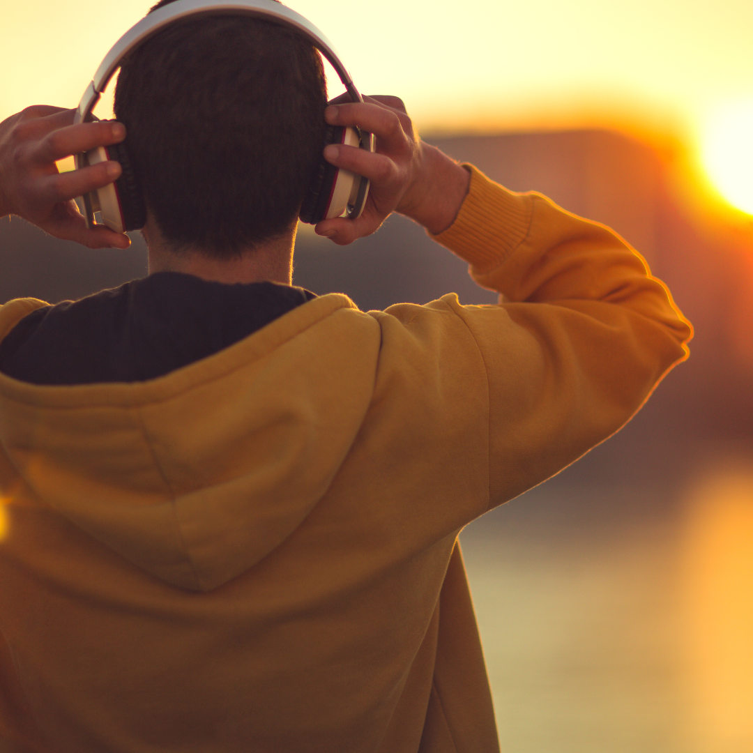 un joven de espaldas, posiblemente escuchando música a través de auriculares