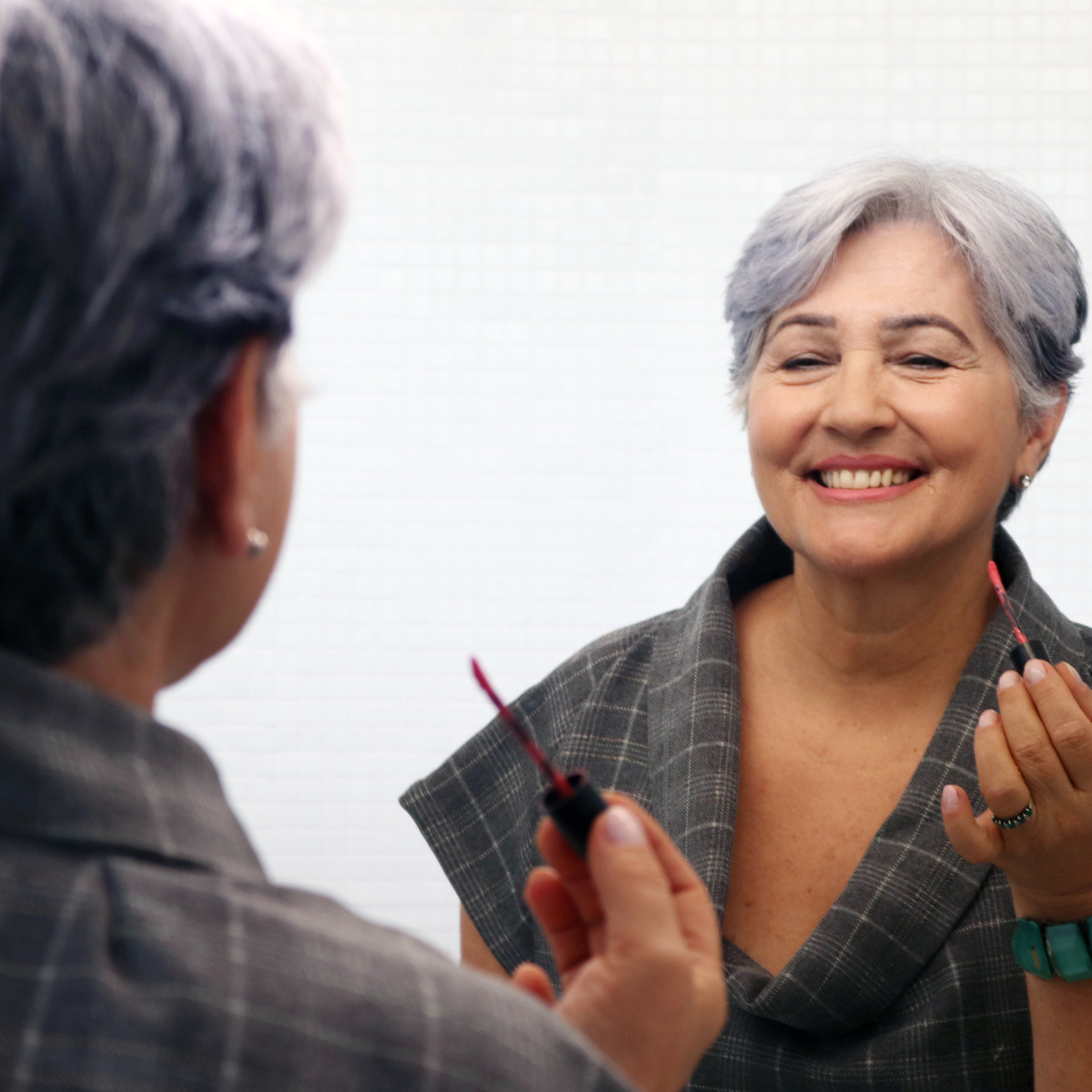 una mujer frente a un espejo sonriendo