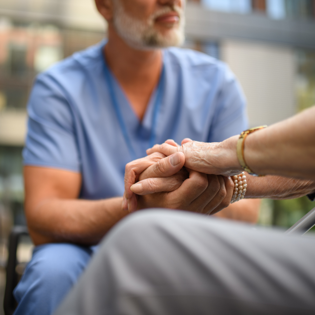 un profesional de la salud sosteniendo las manos de una persona mayor